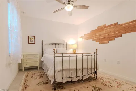 a spacious bedroom with a bed and ceiling fan