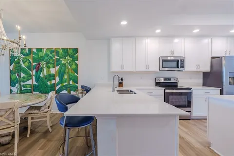 a kitchen with stainless steel appliances a stove a sink a microwave a refrigerator and cabinets