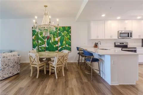 a dining room with furniture a chandelier and wooden floor