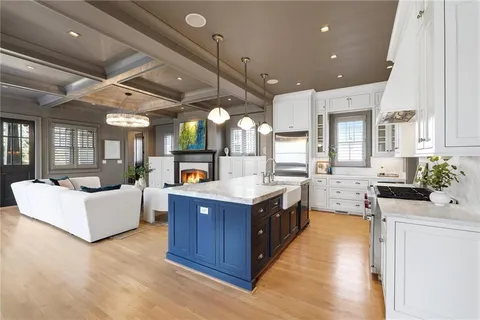 a large kitchen with stainless steel appliances a stove a sink dishwasher and a dining table with the living room view