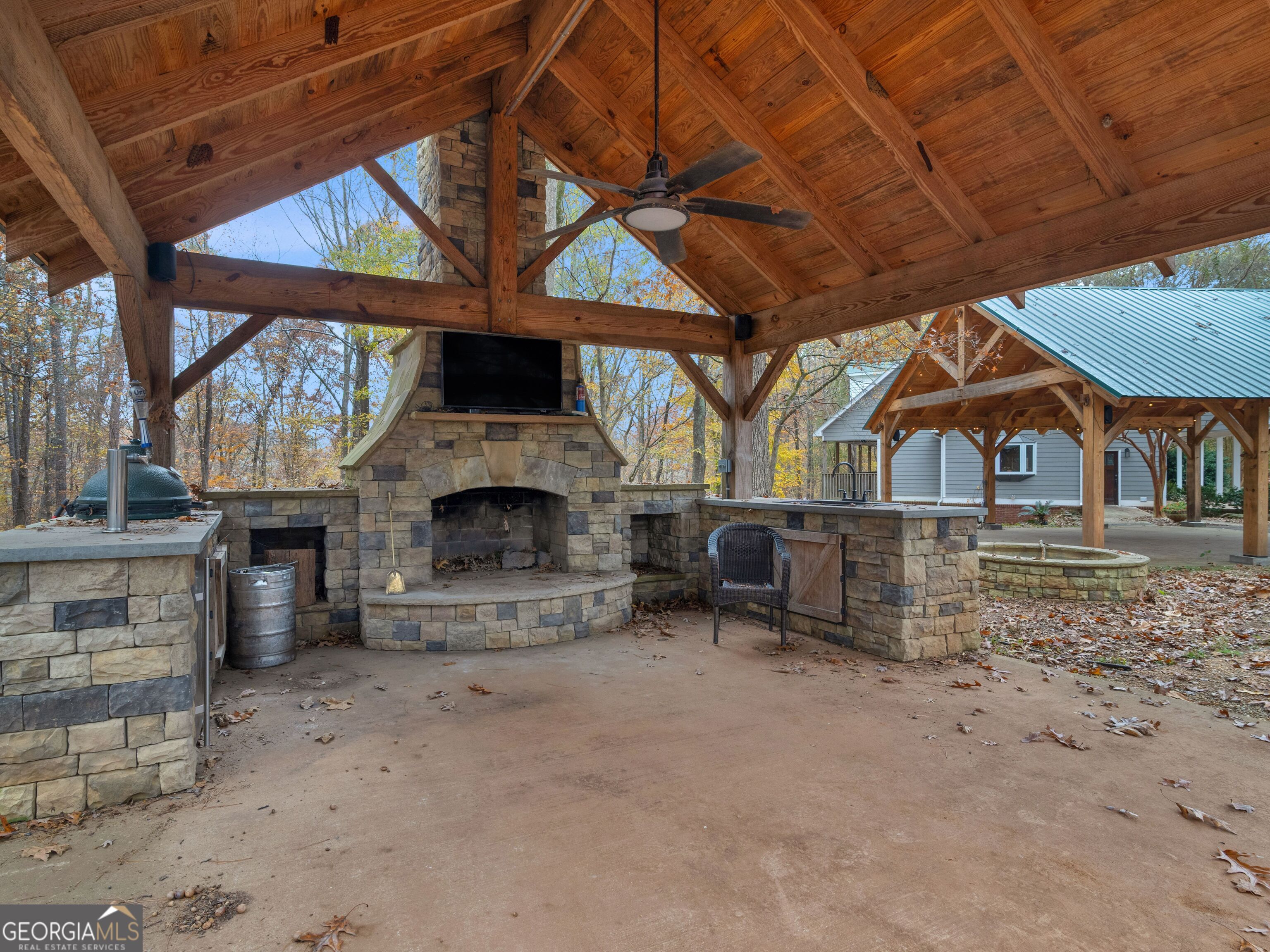 879 Rocky Creek Road Hampton, GA 30228 - Photo 4 of 29 a view of a fireplace with a table and chairs under an umbrella