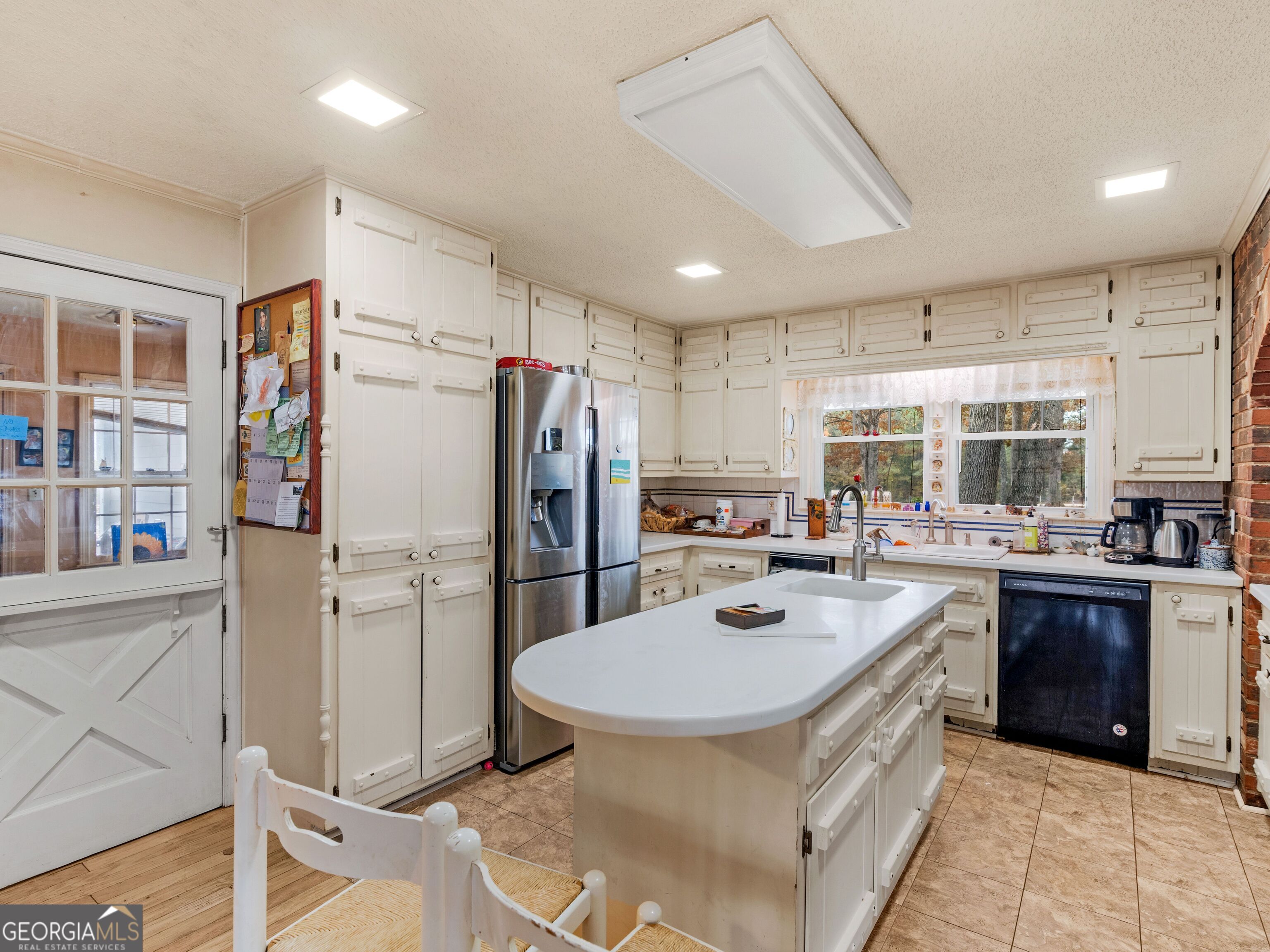 879 Rocky Creek Road Hampton, GA 30228 - Photo 6 of 29 a kitchen with a sink a refrigerator and cabinets