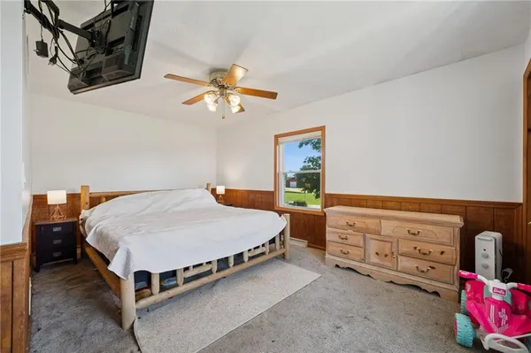 a spacious bedroom with a bed a dresser and cabinets