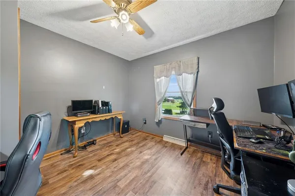 a work room with furniture a window and a wooden floor
