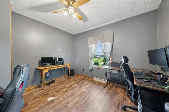 a work room with furniture a window and a wooden floor