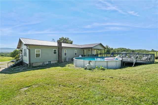 a view of a house with pool and chairs in front of house
