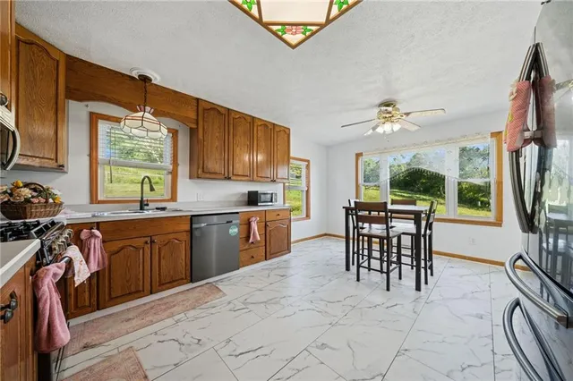 a kitchen with granite countertop a sink cabinets and appliances