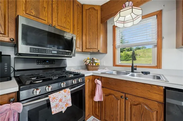 a kitchen with stainless steel appliances a stove sink and microwave