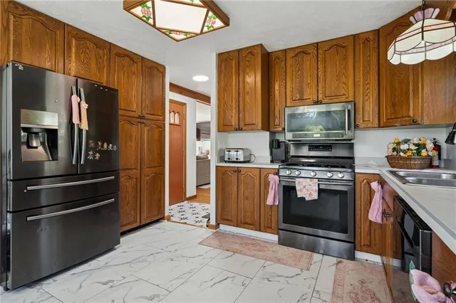 a kitchen with stainless steel appliances granite countertop a refrigerator stove and microwave