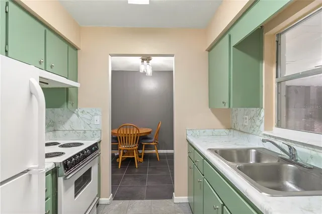 a kitchen that has a sink and a stove with chairs