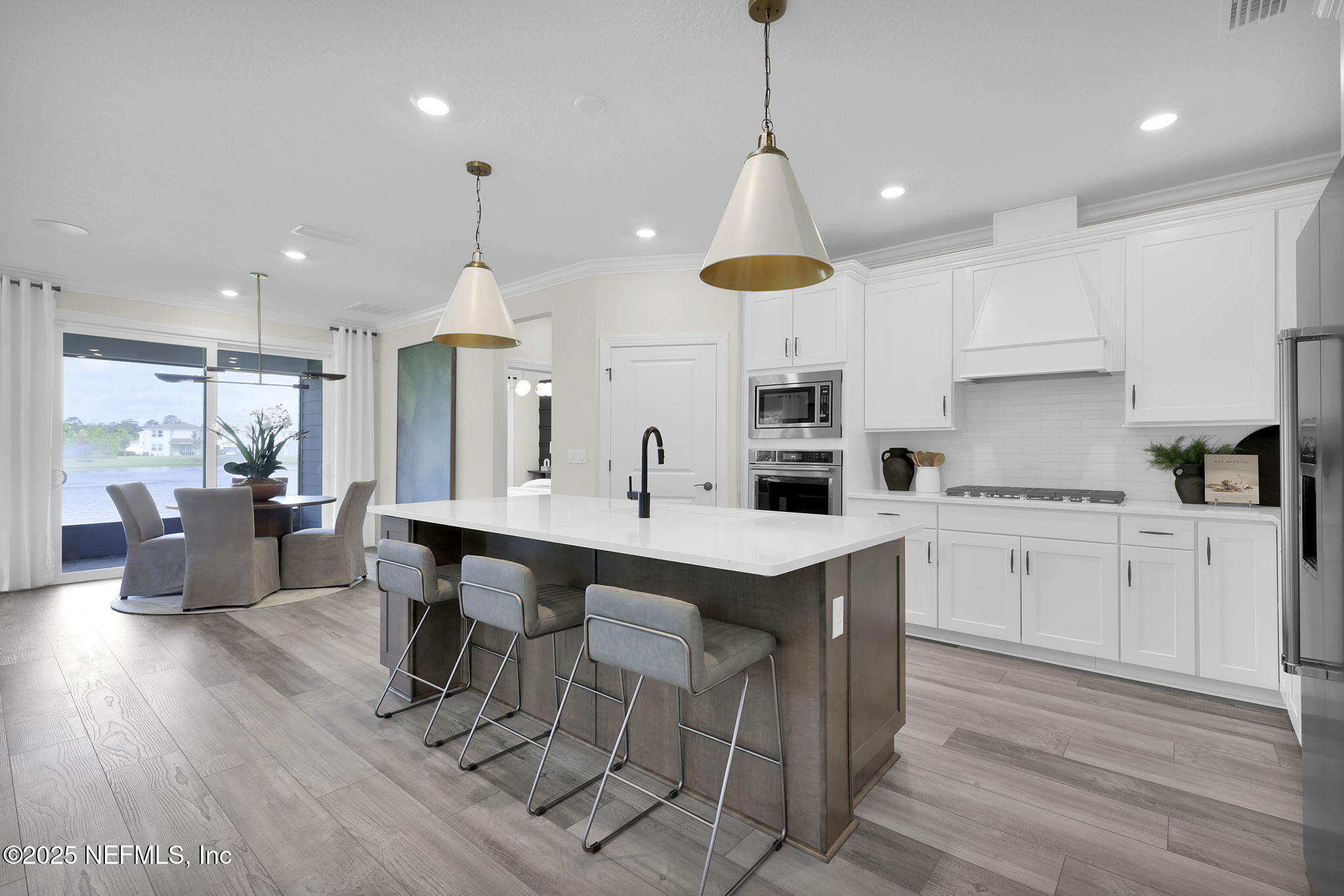 168 Coordinate Lane St. Johns, FL 32259 - Photo 4 of 22 a kitchen with stainless steel appliances kitchen island granite countertop a sink a stove a dining table and chairs with wooden floor