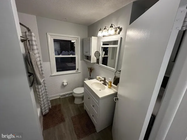 a bathroom with a toilet sink and mirror