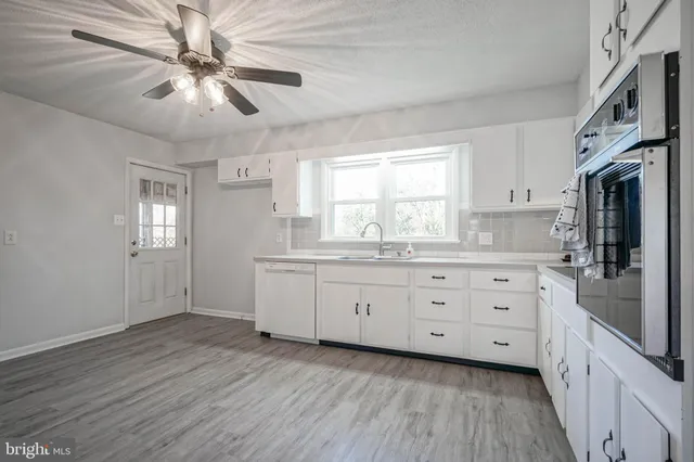 a kitchen with a white wooden cabinets and white stainless steel appliances