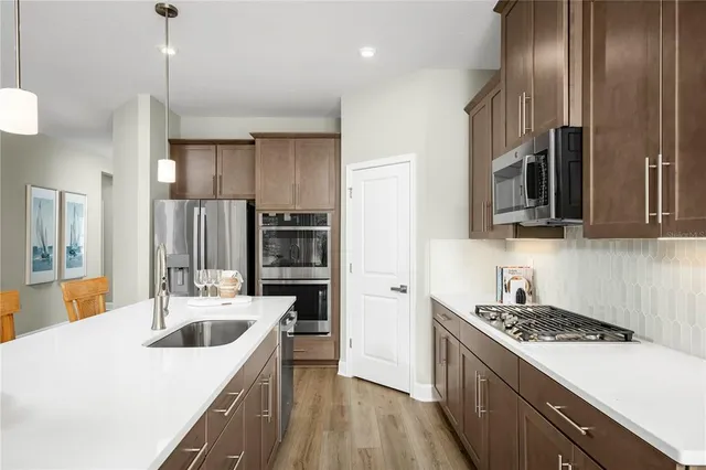 a kitchen with stainless steel appliances granite countertop a sink stove and refrigerator