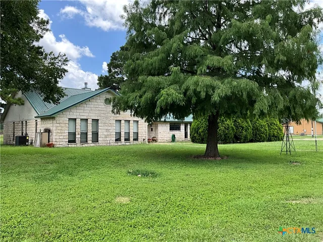 a front view of a house with a yard and trees