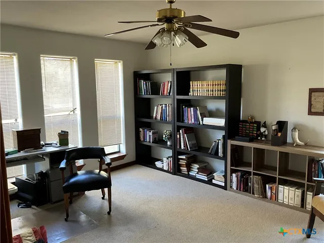 a view of a livingroom with workspace and a window