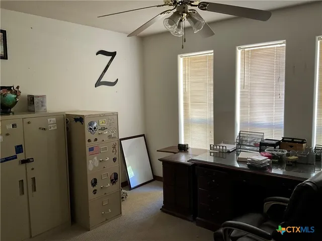 a view of a workspace with furniture and a window