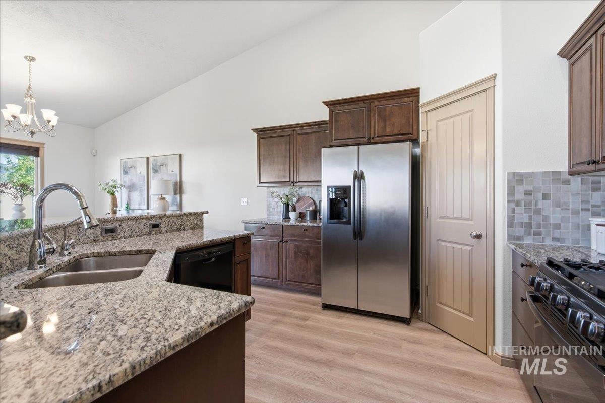 1183 North Buffalo Way Middleton, ID 83644 - Photo 14 of 47 Kitchen featuring wood-finish flooring, dark wood cabinetry, and stainless steel appliances