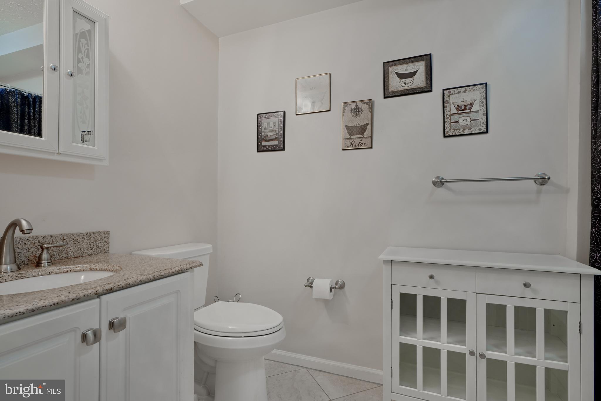 5318 Millfield Road, Unit 5318 Rosedale, MD 21237 - Photo 12 of 26 a bathroom with a toilet sink vanity and mirror
