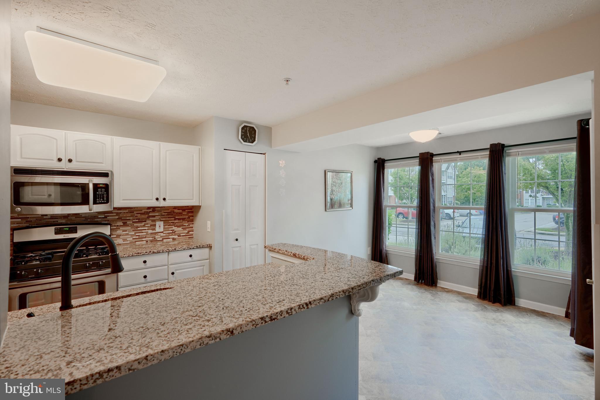 5318 Millfield Road, Unit 5318 Rosedale, MD 21237 - Photo 3 of 26 a kitchen with granite countertop a stove and a refrigerator