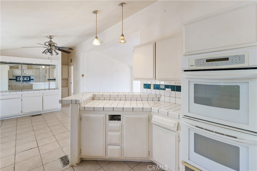 34881 Los Nogales Road Temecula, CA 92592 - Photo 27 of 50 Another view in the kitchen looking into the dining room. Pendant lighting above the counter. Double ovens.