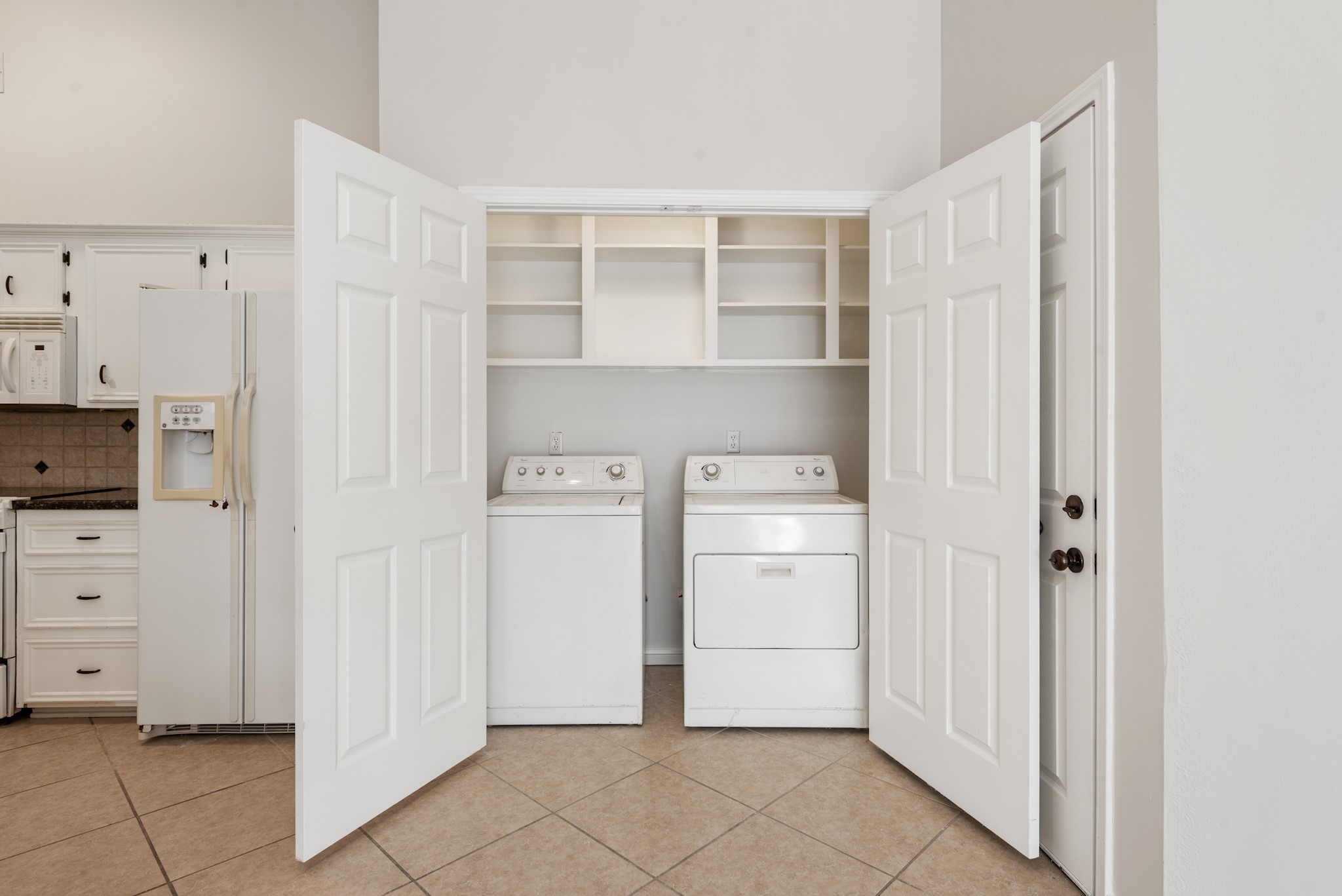 4505 Kensington Road Bryan, TX 77802 - Photo 23 of 26 In home laundry space with built in shelving, washer and dryer