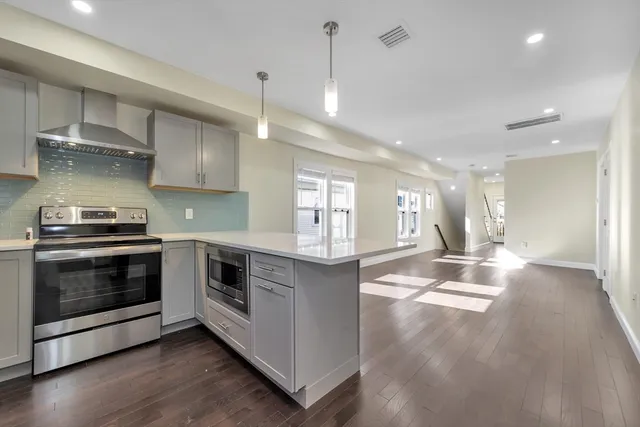 a kitchen with stainless steel appliances granite countertop a stove and cabinets