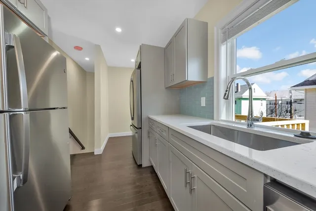 a view of a kitchen with a sink and refrigerator