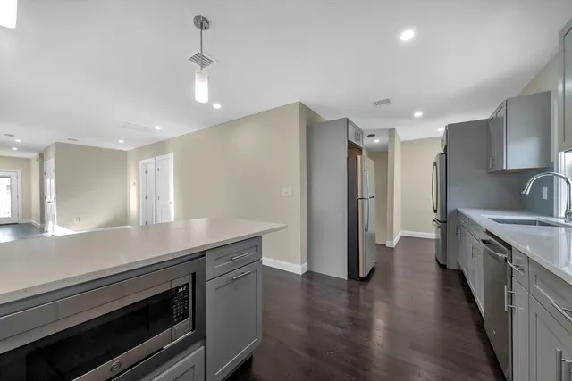 a kitchen with granite countertop a sink stainless steel appliances and cabinets