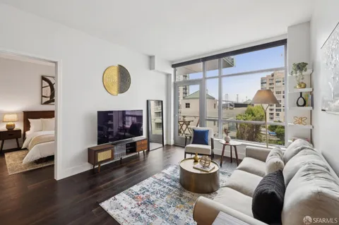 a living room with furniture potted plant and a large window