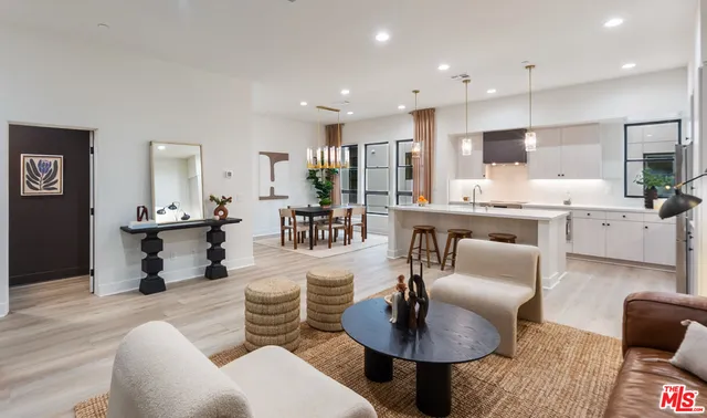 a living room with furniture kitchen view and a table