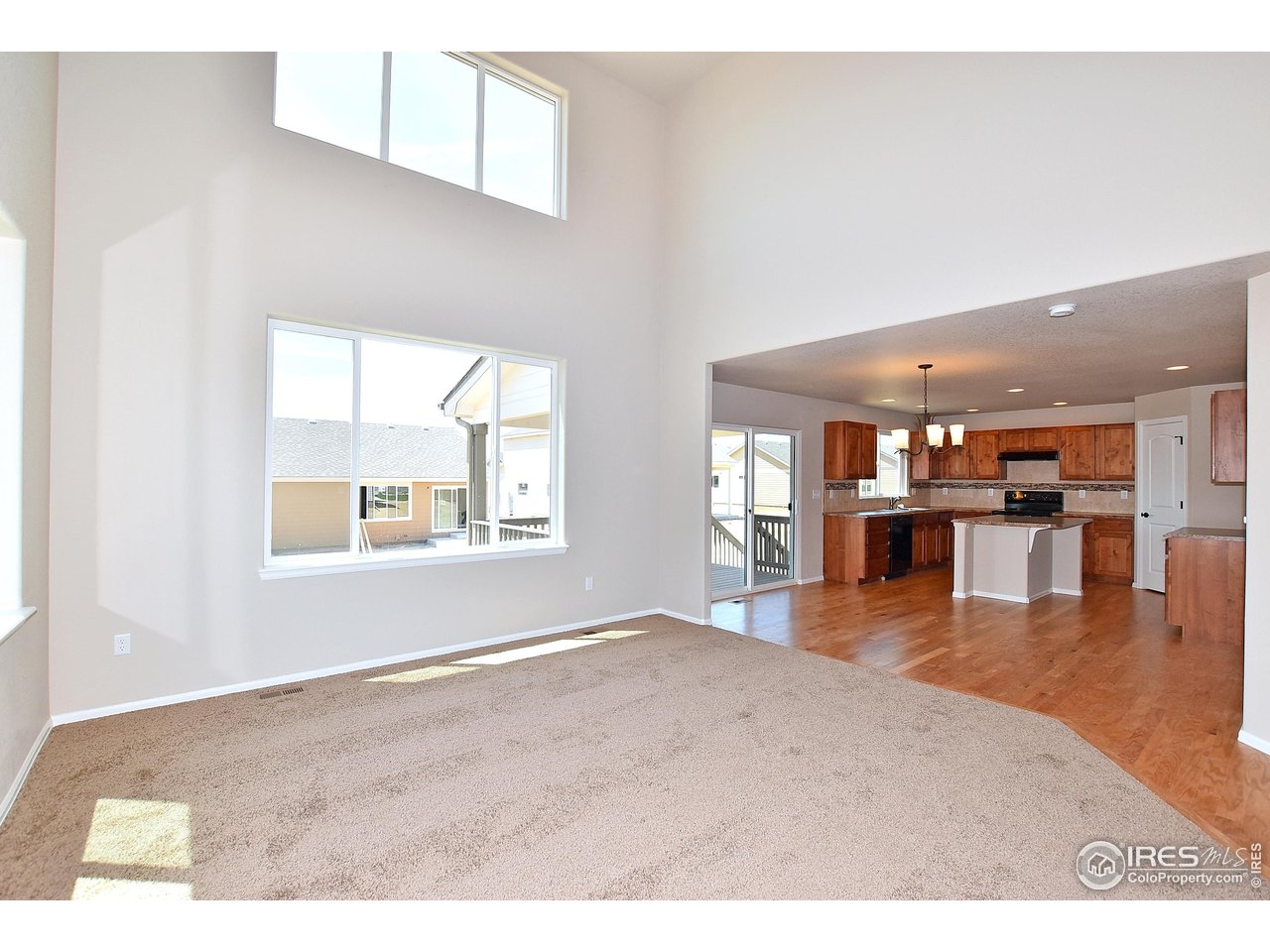 312 August Lane Windsor, CO 80550 - Photo 13 of 40 an empty room with wooden floor and windows