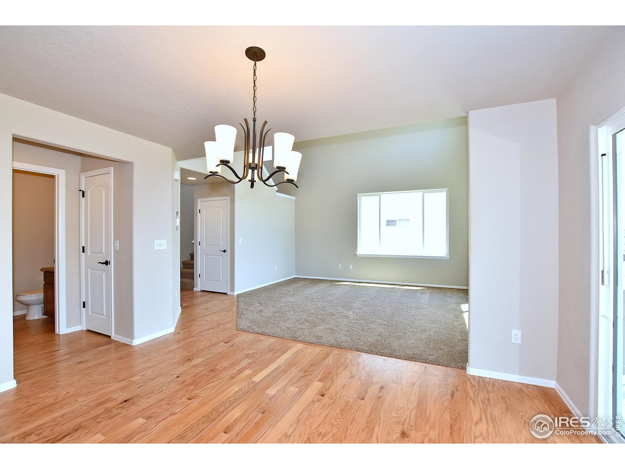 312 August Lane Windsor, CO 80550 - Photo 23 of 40 a view interior of a house an empty space a chandelier and wooden floor