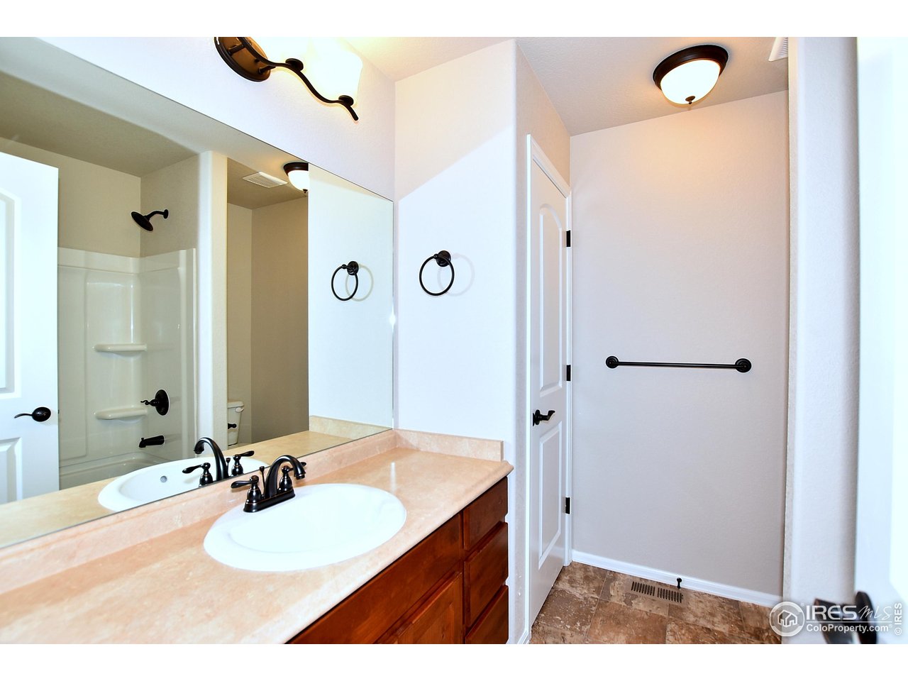 312 August Lane Windsor, CO 80550 - Photo 34 of 40 a bathroom with a sink vanity granite shower and a mirror