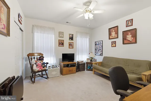 a living room with furniture a piano and a flat screen tv