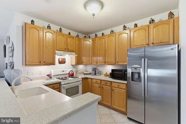 a kitchen with a sink a refrigerator and cabinets
