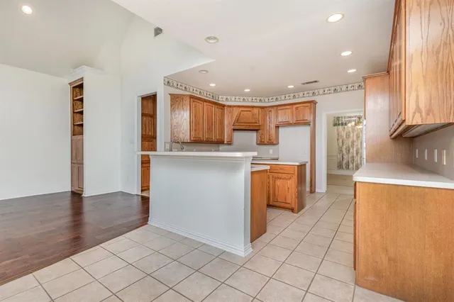 a kitchen with stainless steel appliances granite countertop a refrigerator a sink dishwasher and a stove with wooden floors