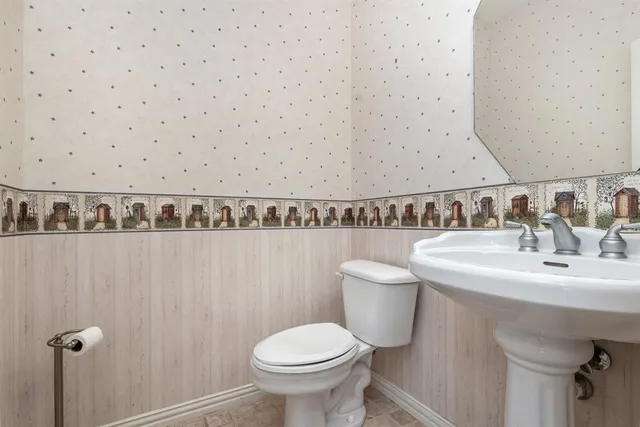 a bathroom with a sink a toilet and mirror