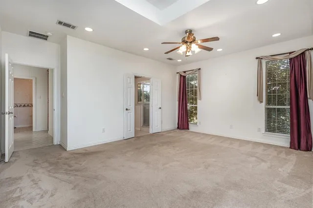 an empty room with closet and a chandelier fan