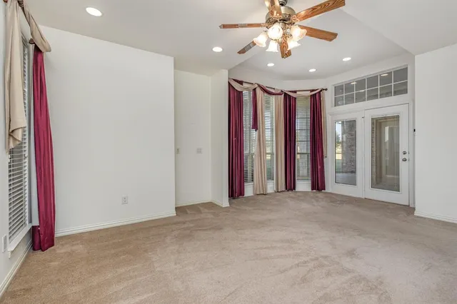 a view of empty room with window and ceiling fan