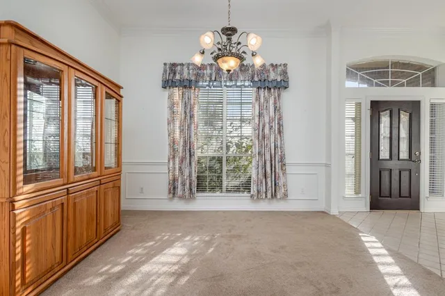 a view of a hallway with windows and chandelier