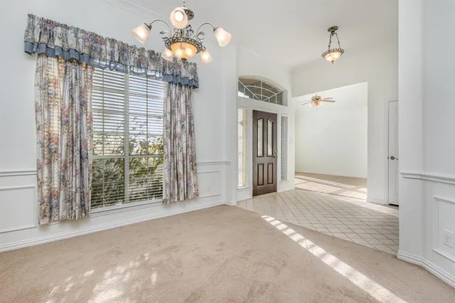 a view of a livingroom with a chandelier fan and windows