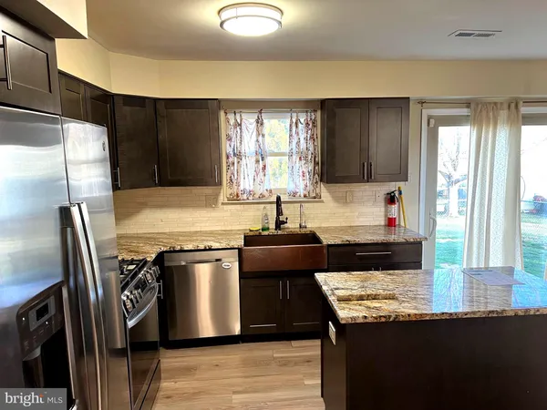 a kitchen with a stove a sink and a refrigerator