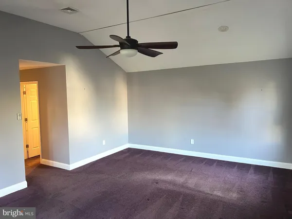 an empty room with a ceiling fan and a window