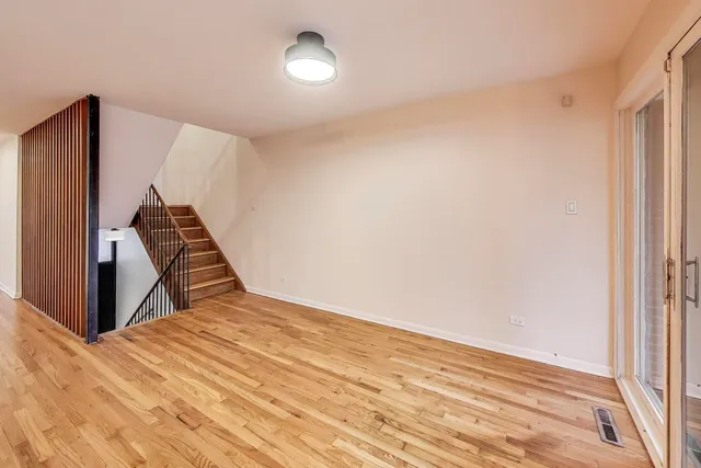 a view of a livingroom with wooden floor and staircase