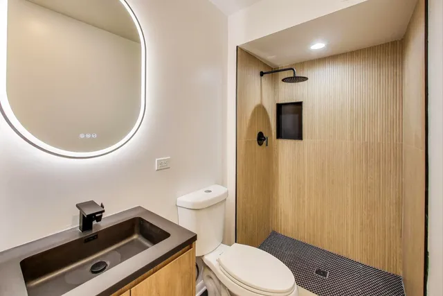 a bathroom with a sink a toilet and a mirror