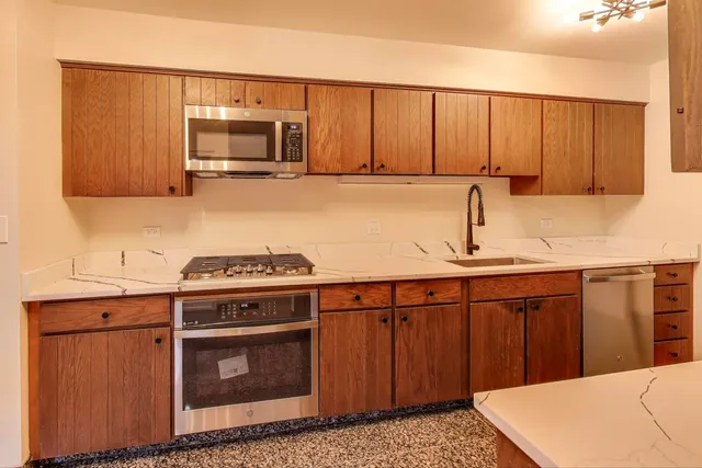 a kitchen with stainless steel appliances granite countertop a sink stove and microwave
