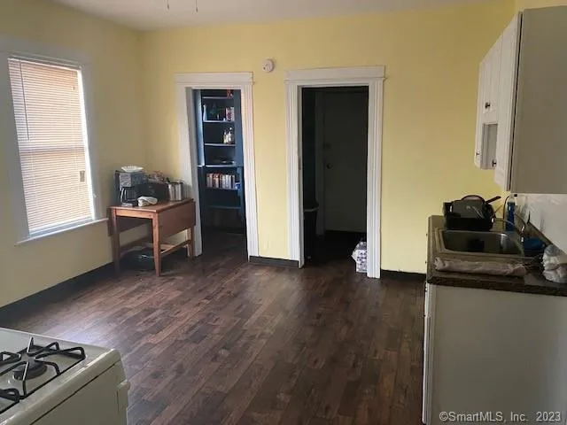 a kitchen with white cabinets and white appliances