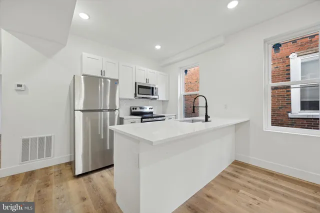 a kitchen with a refrigerator sink and cabinets