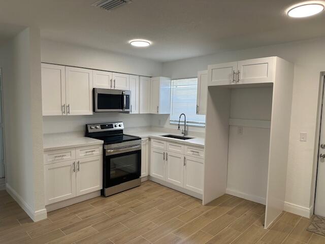 491 West Jordan Boulevard Pahokee, FL 33476 - Photo 2 of 10 a kitchen with a sink cabinets and stainless steel appliances